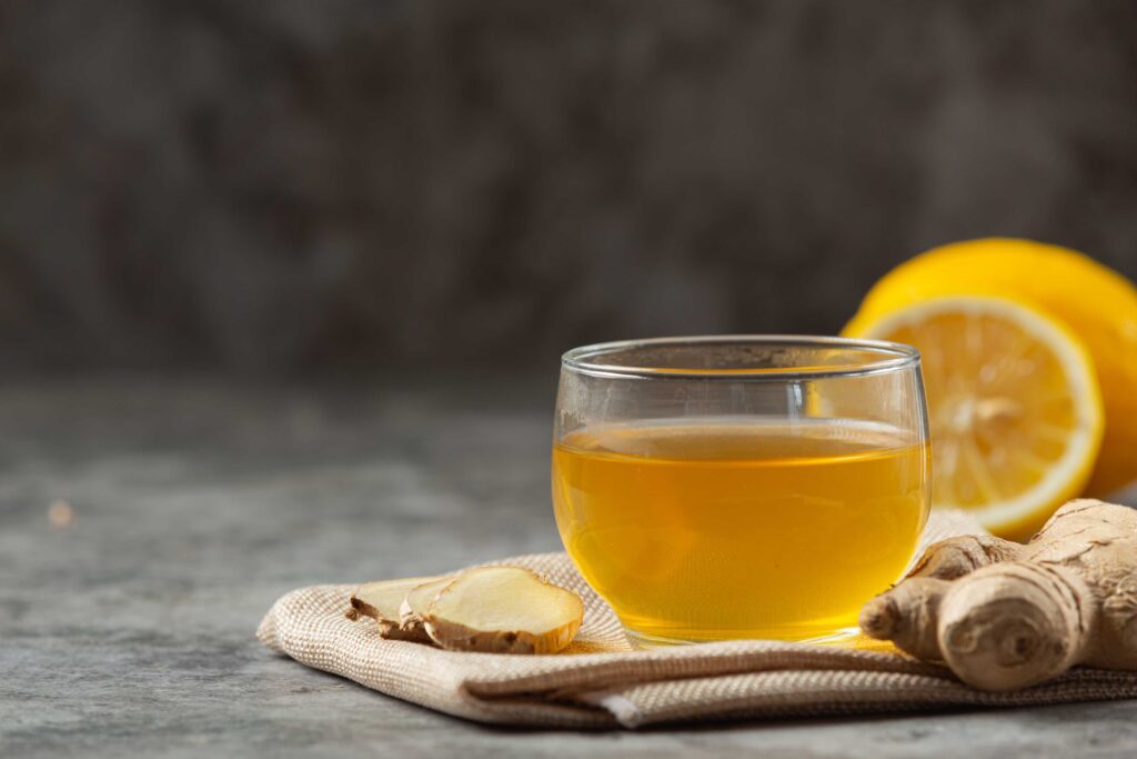 Glass of lemon ginger detox water with honey on wooden table